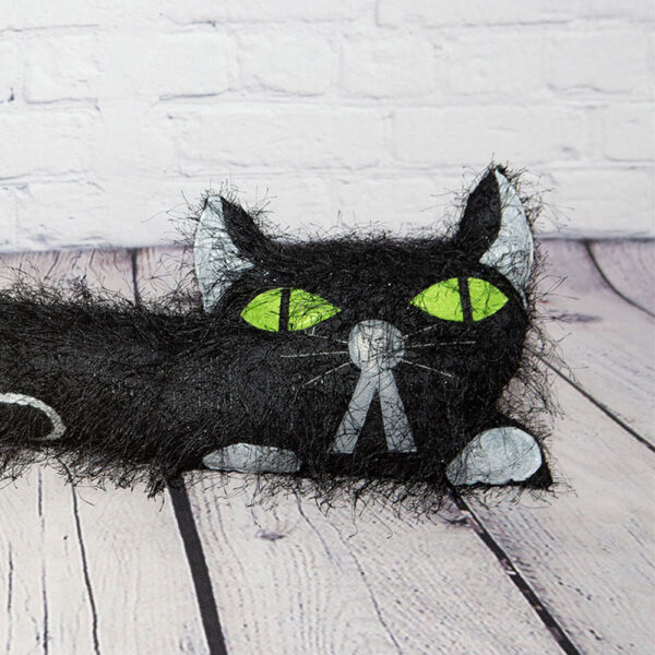 Long Haired Black Flat Cat Draft Excluder Green Eyes Closeup